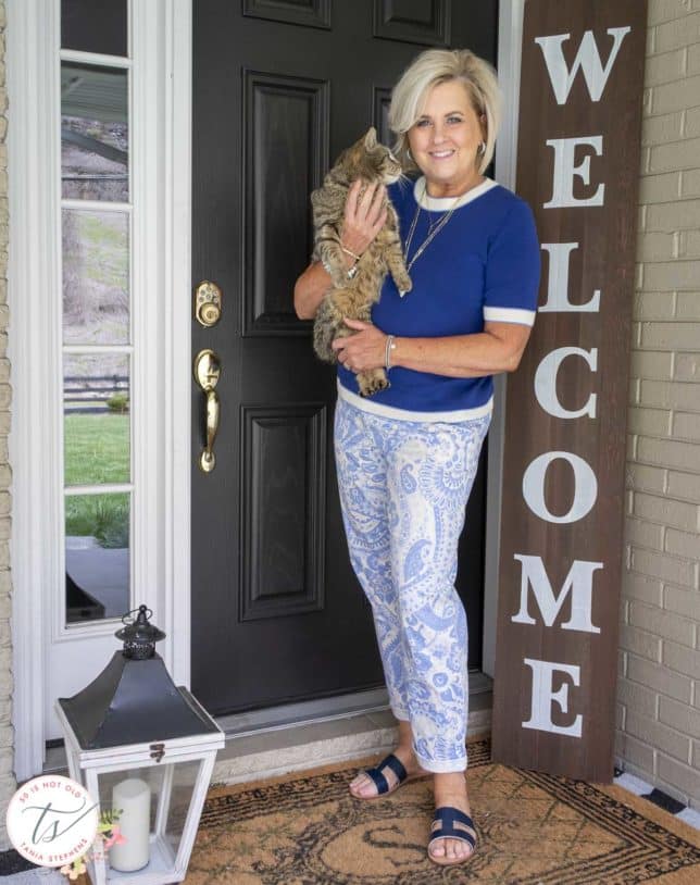 Fashion Blogger 50 Is Not Old is wearing a cobalt blue sweater, blue and white paisley pants, and a navy pair of sandals