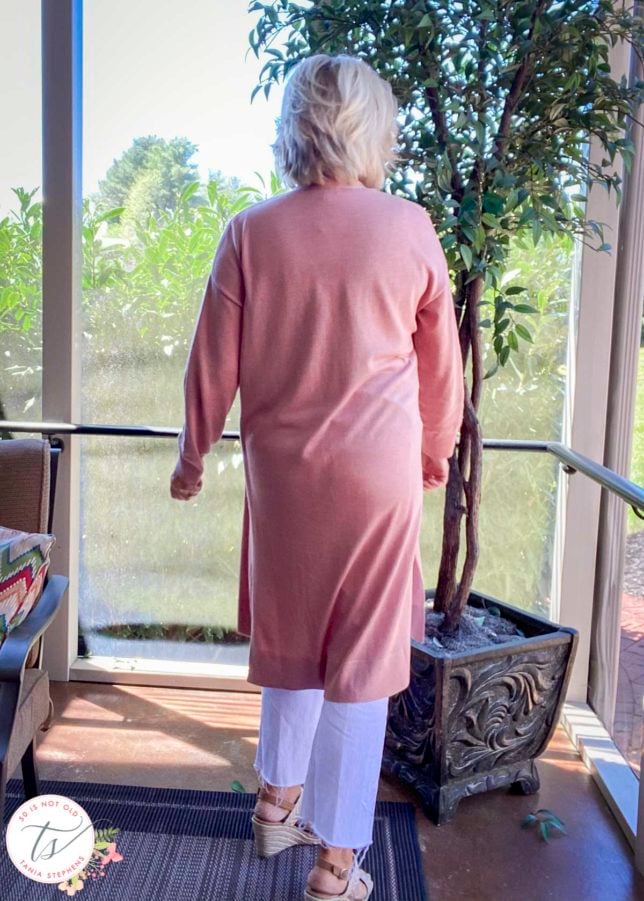 Fashion Blogger 50 Is Not Old is showing the back of a rose duster, white cropped pants, and espadrilles