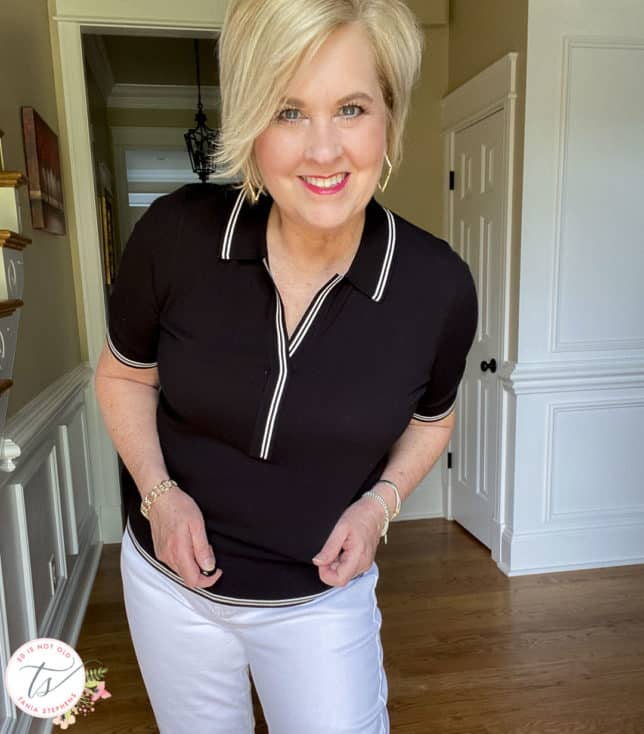 Fashion Blogger 50 Is Not Old is wearing a black polo sweater with white edging with gold jewelry