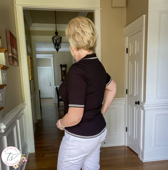 Fashion Blogger 50 Is Not Old is showing the back of a black polo sweater with white edging