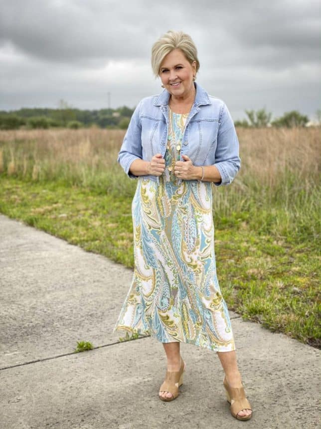Fashion Blogger 50 Is Not Old is wearing a cropped denim jacket with a paisley print maxi dress