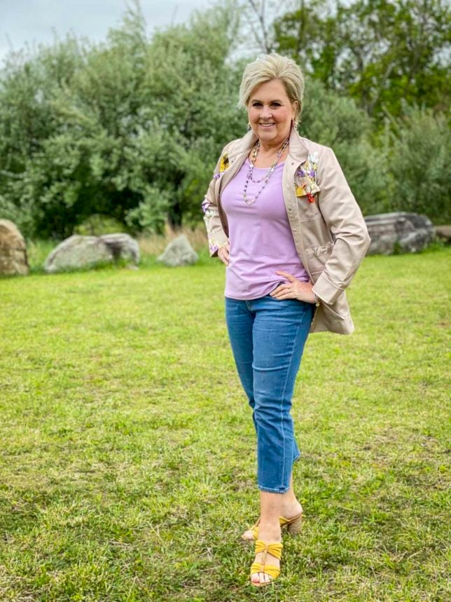 Fashion Blogger 50 Is Not Old is wearing a beautiful pale lavender tee with a floral satin utility jacket and cropped flare jeans from Chicos