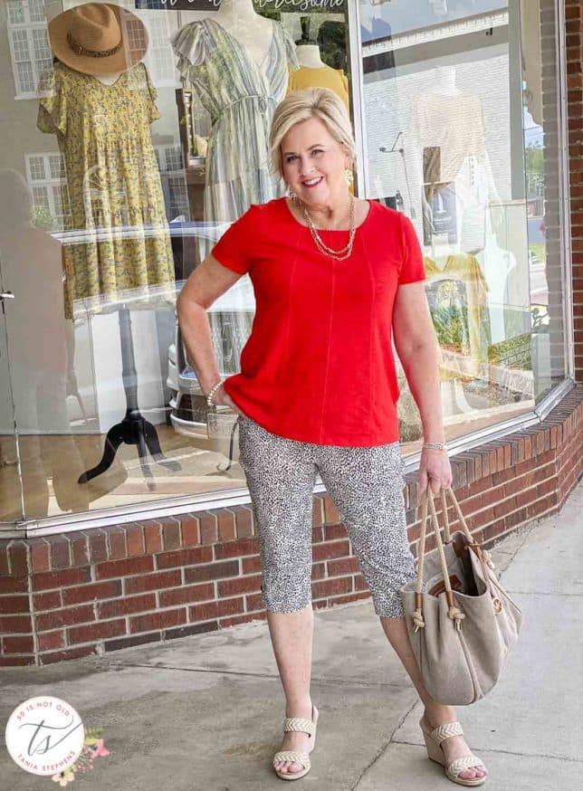 Fashion Blogger 50 Is Not Old is out shopping in animal print capri pants and a bright red top