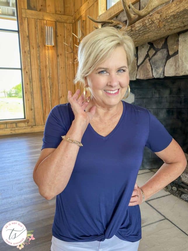 Fashion Blogger 50 Is Not Old is wearing a navy top while showing her gold jewelry
