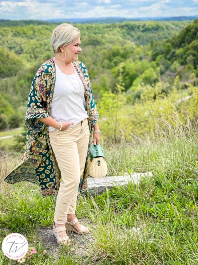 Fashion Blogger 50 Is Not Old is wearing a duster cardigan with a beige tank and pale gold jeans