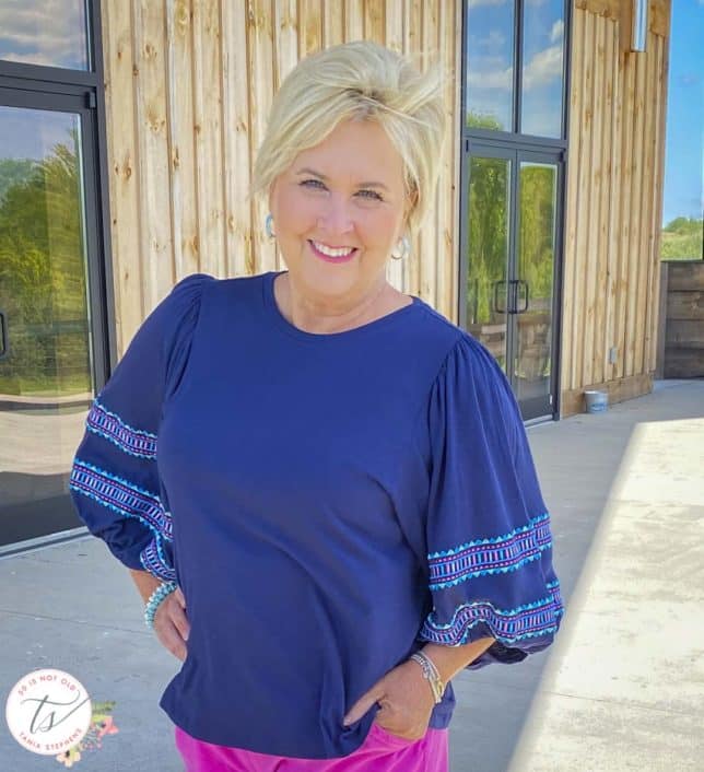 Fashion Blogger 50 Is Not Old is wearing a navy top with embroidered balloon sleeves