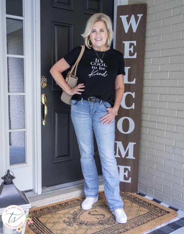 Fashion Blogger 50 Is Not Old is wearing a black and white graphic t-shirt, light jeans, and white Keds sneakers