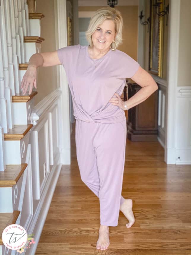 Fashion Blogger 50 Is Not Old is wearing a front twist top, cropped pants in light grape, and is barefooted