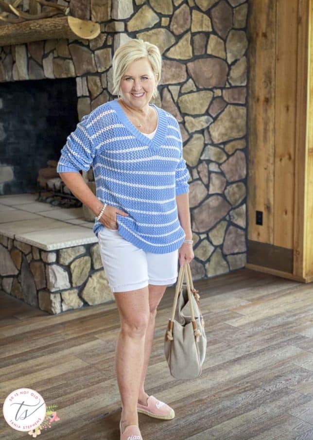 Fashion Blogger 50 Is Not Old is wearing a blue and white striped mesh sweater with white denim shorts, pink espadrilles, and carrying a Michael Kors tote