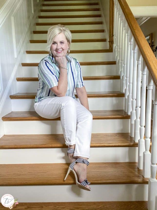 Fashion Blogger 50 Is Not Old is wearing a striped top with white jeans and navy and white gingham heels