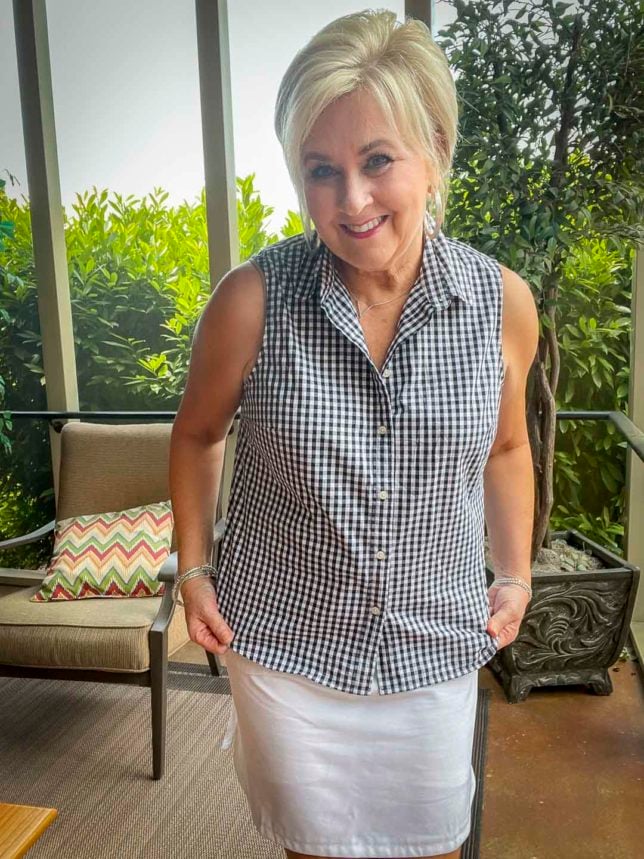 Fashion Blogger 50 Is Not Old is wearing a navy and white button up sleeveless shirt with a white skort