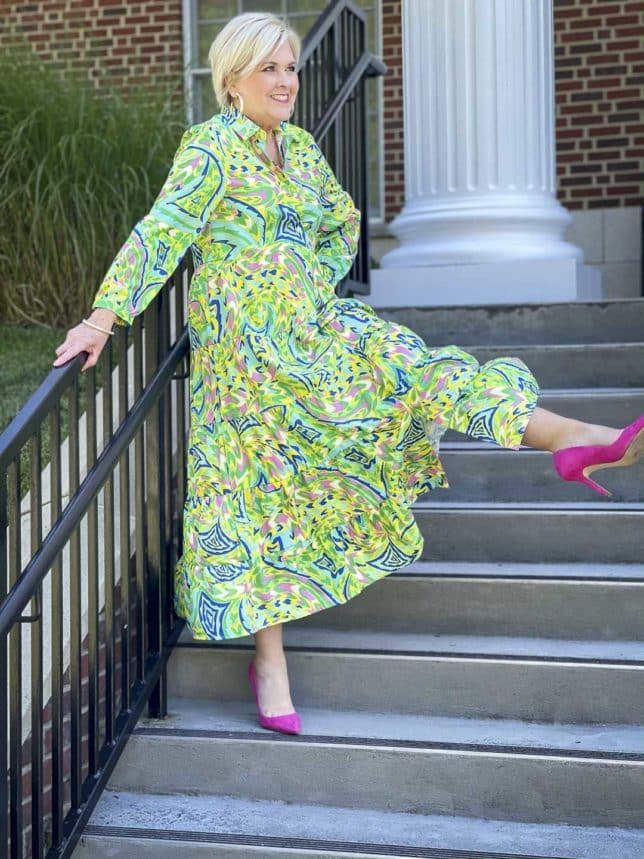 Fashion Blogger 50 Is Not Old is ready for an indoor wedding in this colorful tropical midi shirt dress with bright pink pumps