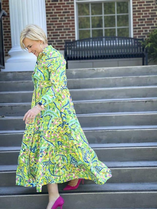 Fashion Blogger 50 Is Not Old is ready for an indoor wedding in this tropical midi shirt dress with bright pink suede pumps