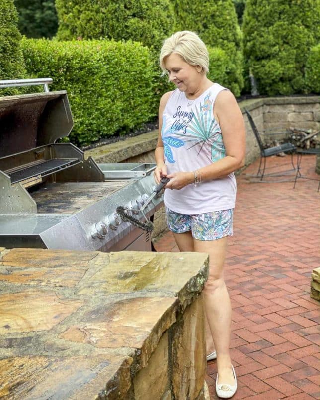 Fashion Blogger 50 Is Not Old is cleaning the grill while wearing pajamas from Vera Bradley
