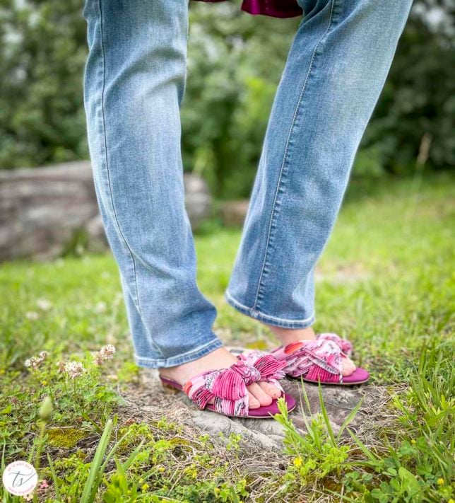 Fashion Blogger 50 Is Not Old is wearing bootcut jeans and pink floral slides