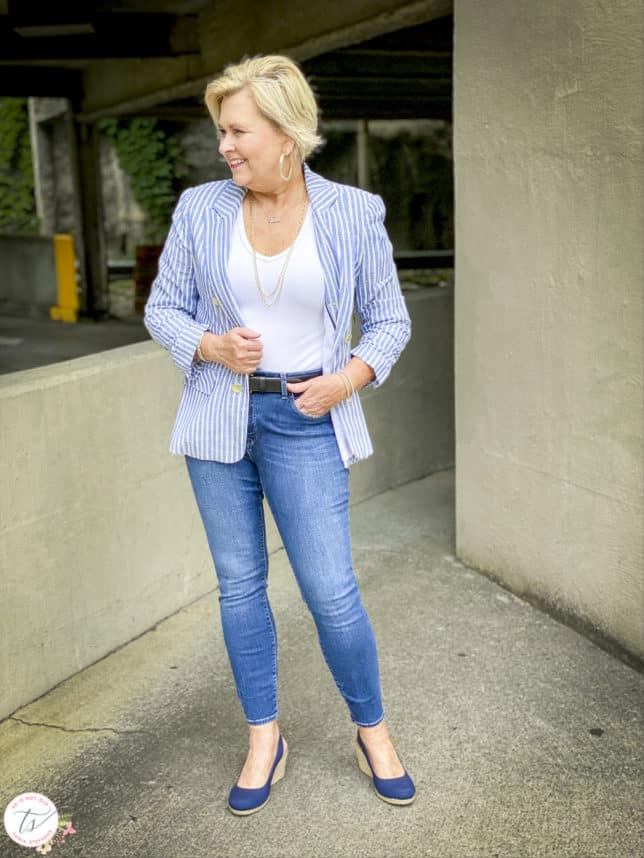 Fashion Blogger 50 Is Not Old is wearing a blue and white blazer, a white v-neck bodysuit, skinny jeans, and navy espadrilles