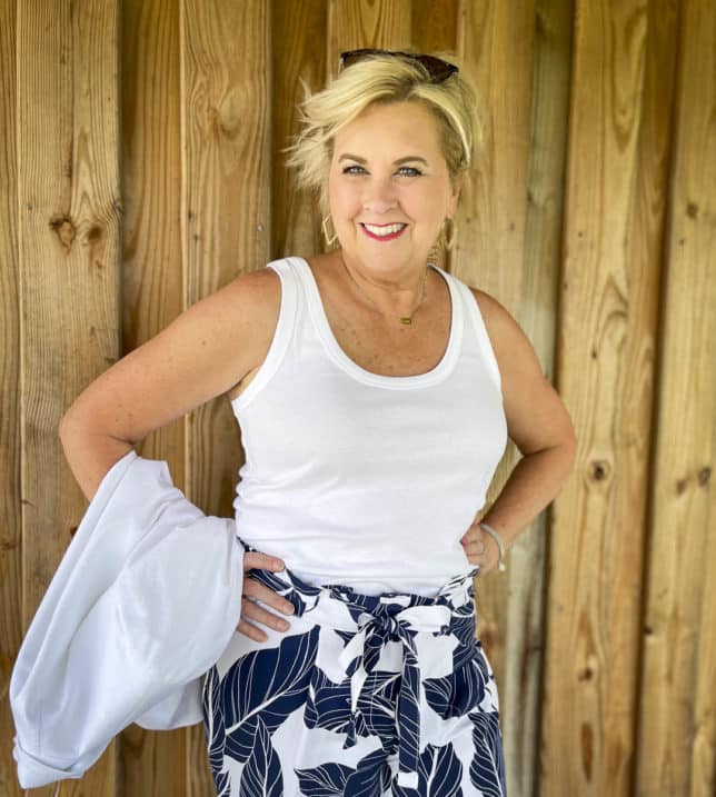 Fashion Blogger 50 Is Not Old is wearing a white tank top with navy and white palm print ankle pants