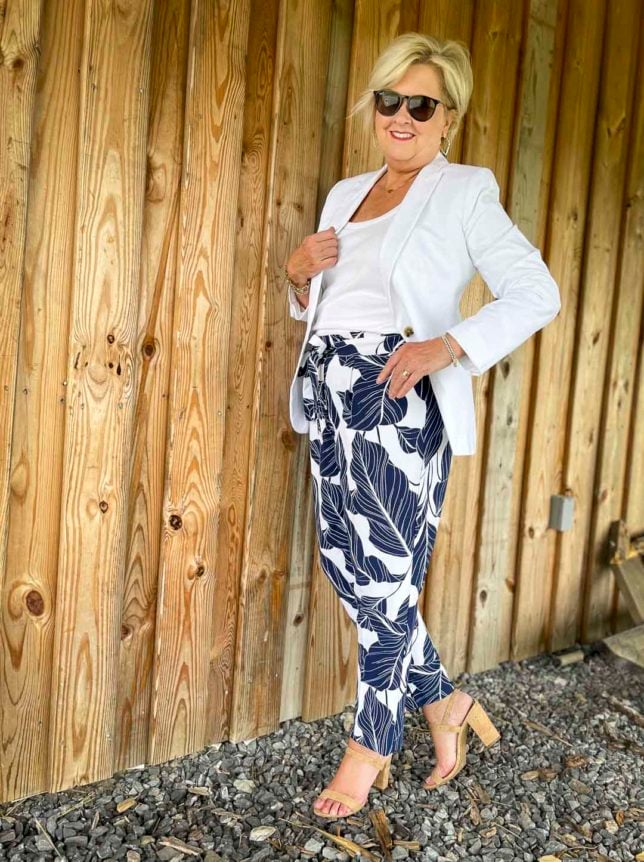 Fashion Blogger 50 Is Not Old is looking cool and crisp in a white on white chic look, sunglasses, and navy and white palm print ankle pants
