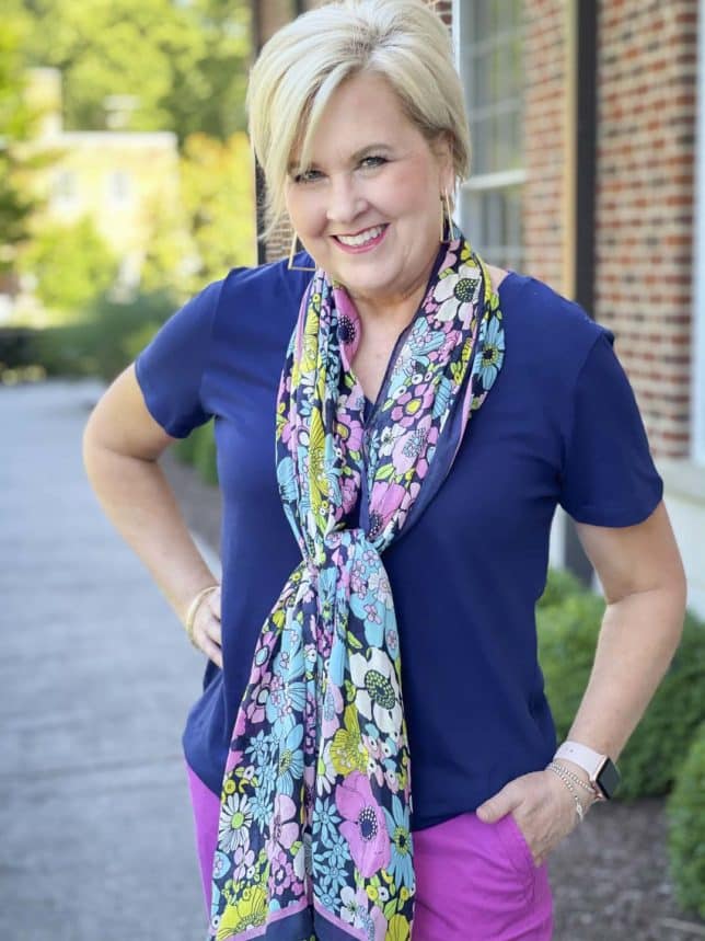 Fashion Blogger 50 Is Not Old is wearing a navy t-shirt with a floral scarf around her neck