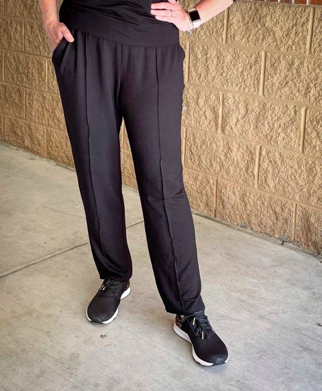 Over 40 Fashion Blogger, Tania Stephens is styling pin tucked black pants with black sneakers with leopard print