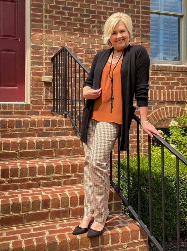 Fashion Blogger 50 Is Not Old is adding pumpkin spice to her wardrobe with this camisole worn with a black cardigan and plaid pants