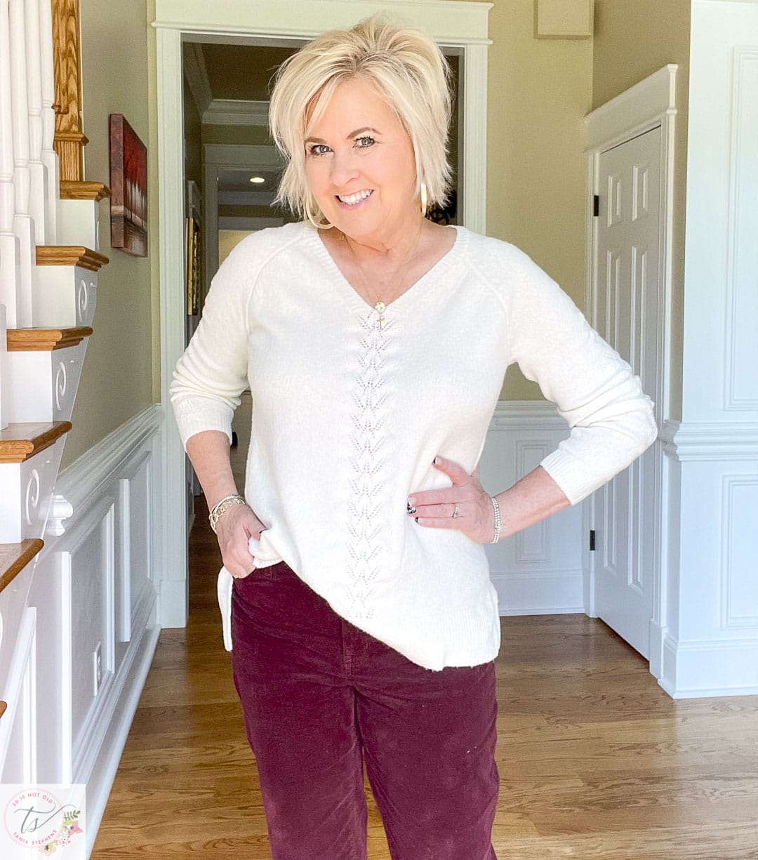 Over 40 fashion blogger, Tania Stephens, is wearing deep plum corduroy straight-leg pants with a cream Pointelle sweater