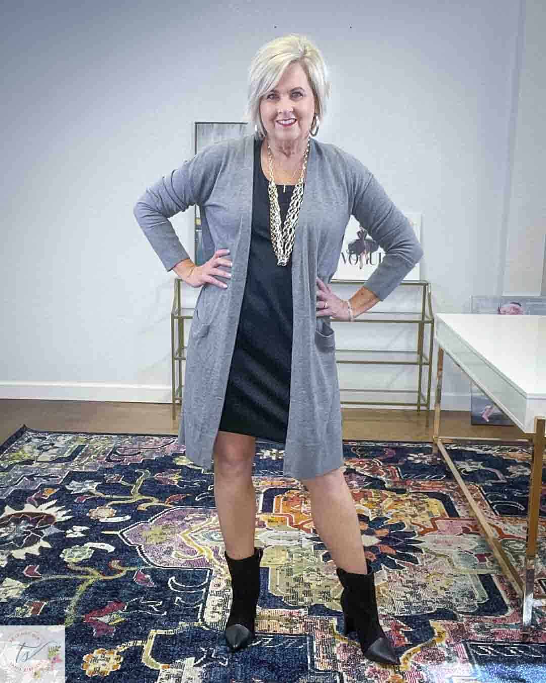 Over 40 Fashion Blogger, Tania Stephens, is wearing a little black dress, a long gray cardigan, gold jewelry, and black suede ankle boots