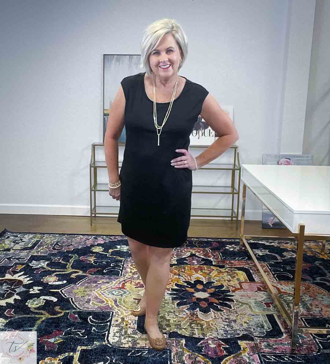 Over 40 Fashion Blogger, Tania Stephens, is wearing a little black dress with gold jewelry and tan Tory Burch flats