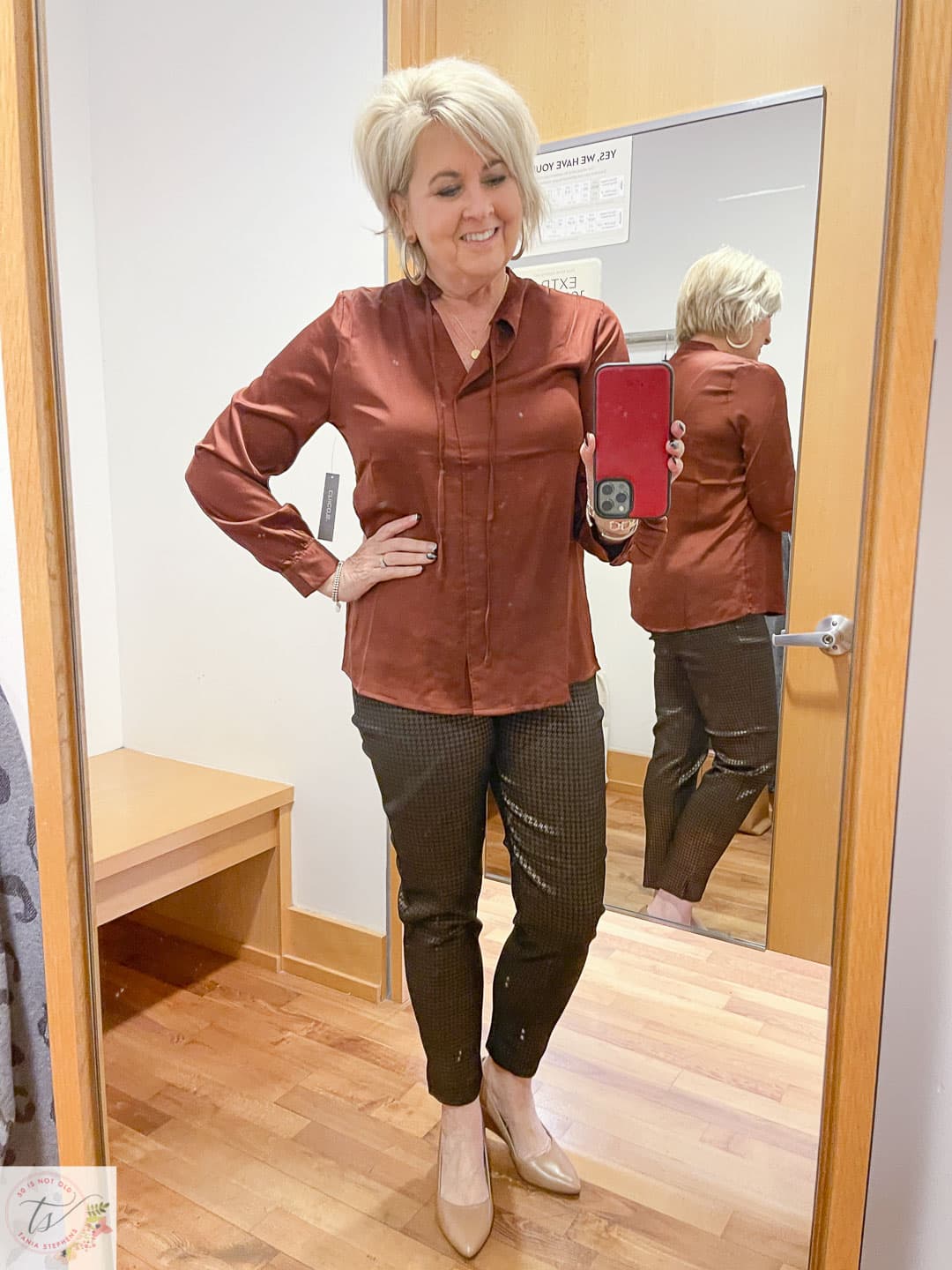 Over 40 Fashion Blogger, Tania Stephens, is trying on a Chico's deep rust satin blouse and black and camel foiled ankle pants