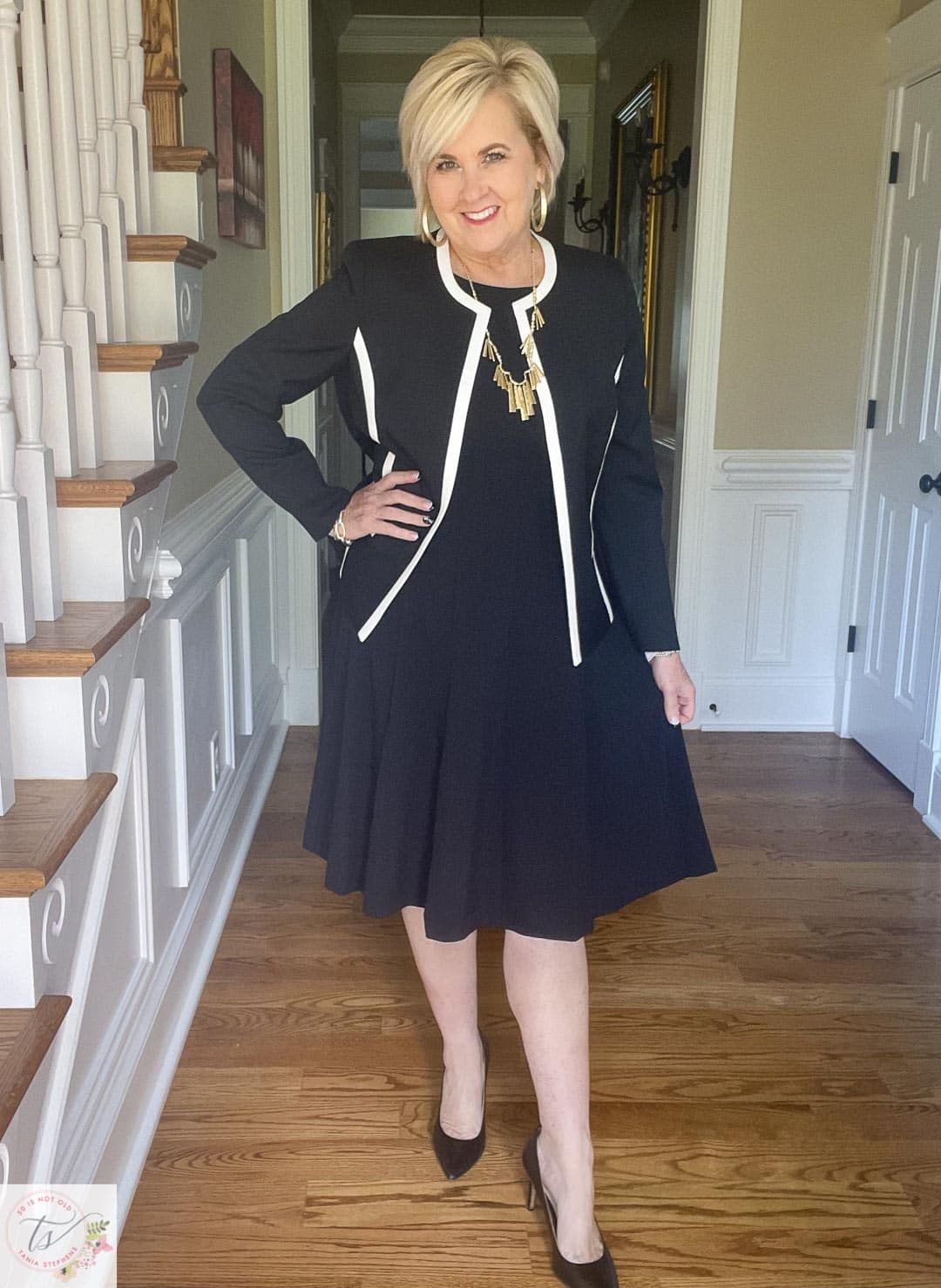 Over 40 Fashion Blogger, Tania Stephens is ready for a fall wedding wearing this black jacket with white trim and black fit and flare dress