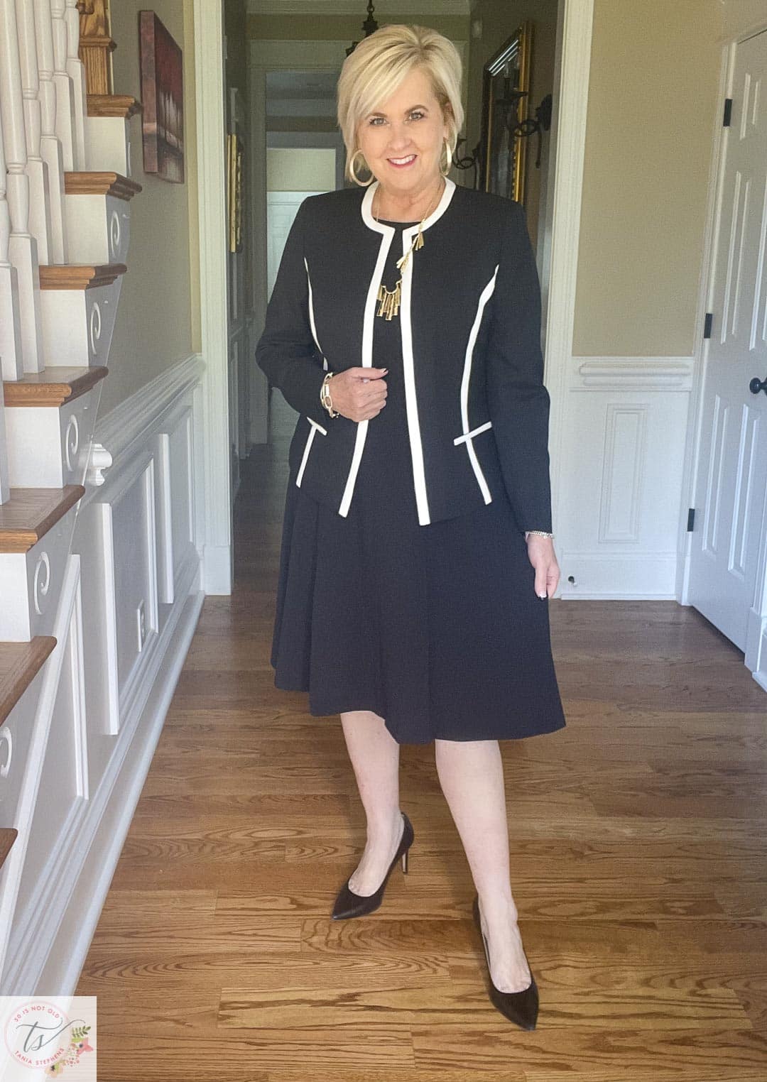 Over 40 Fashion Blogger, Tania Stephens is ready for a fall wedding wearing a black jacket with white trim and black fit and flare dress