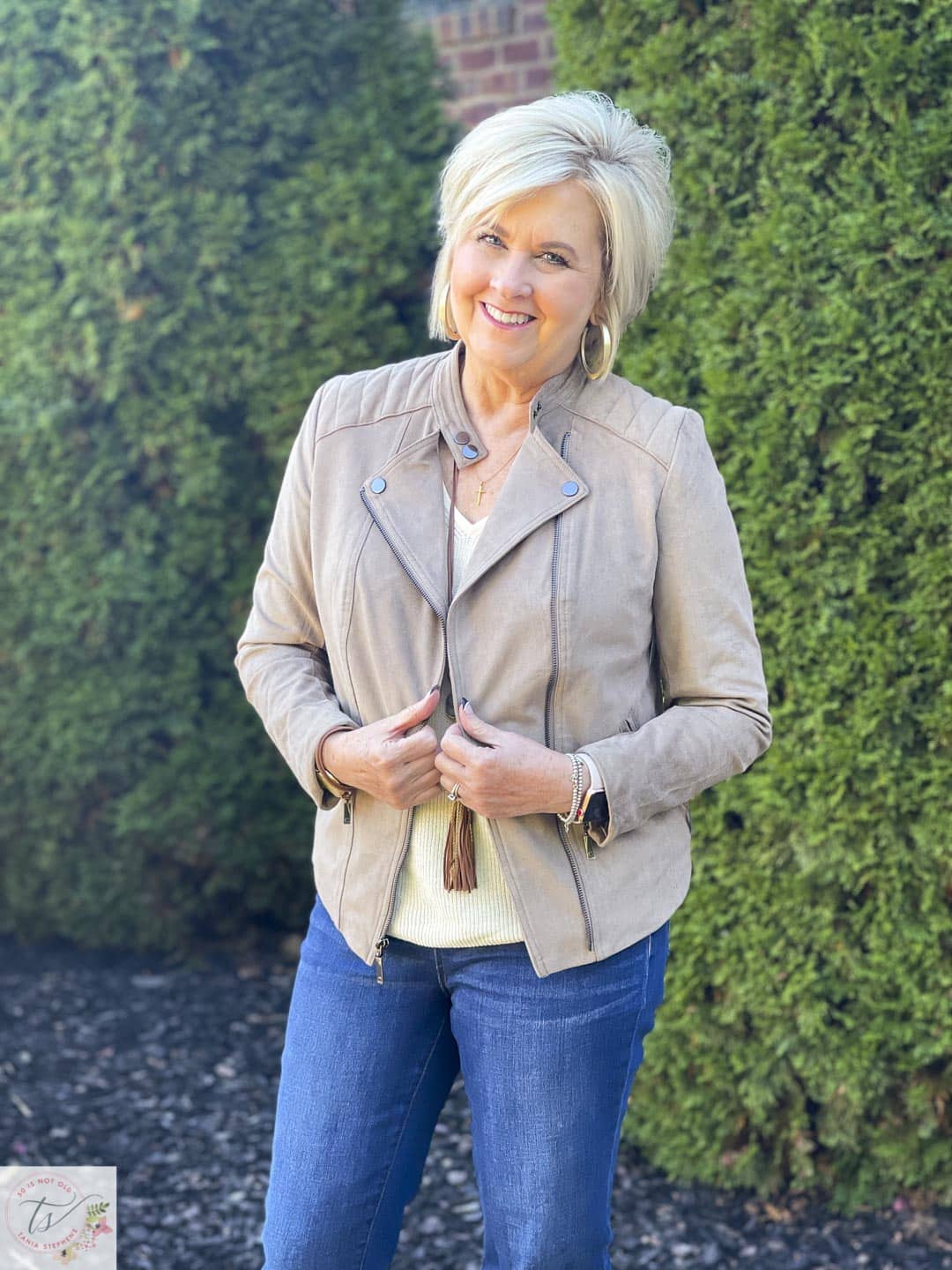 Over 40 Fashion Blogger, Tania Stephens is laughing while wearing a quilted shoulder moto jacket