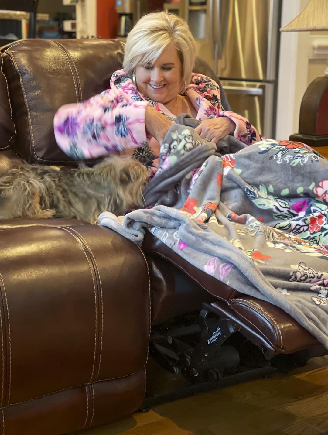 Over 40 fashion blogger, Tania Stephens is staying warm on cold rainy mornings in a robe from Vera Bradley in the Hope Blooms Pink print and sitting on the couch under a Hope Blooms throw blanket