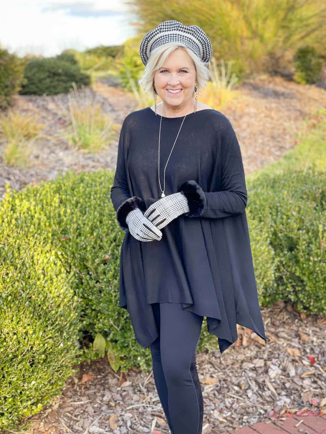 Over 40 Fashion Blogger, Tania Stephens is wearing an all black outfit with a beret and faux-fur trimmed gloves
