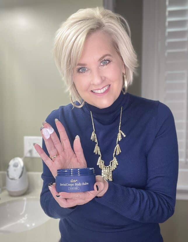 Over 40 Fashion Blogger, Tania Stephens is wearing a navy turtleneck and showing Invisiscape Body Butter by City Beauty