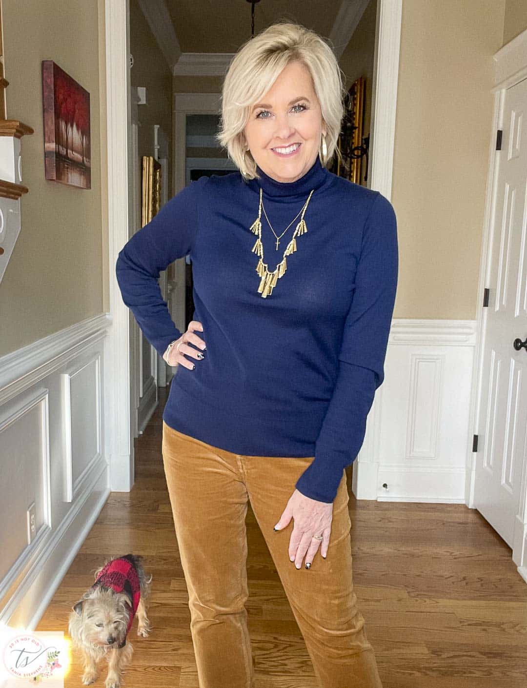 Over 40 Fashion Blogger, Tania Stephens is wearing a navy turtleneck and gold jewelry from Kendra Scott