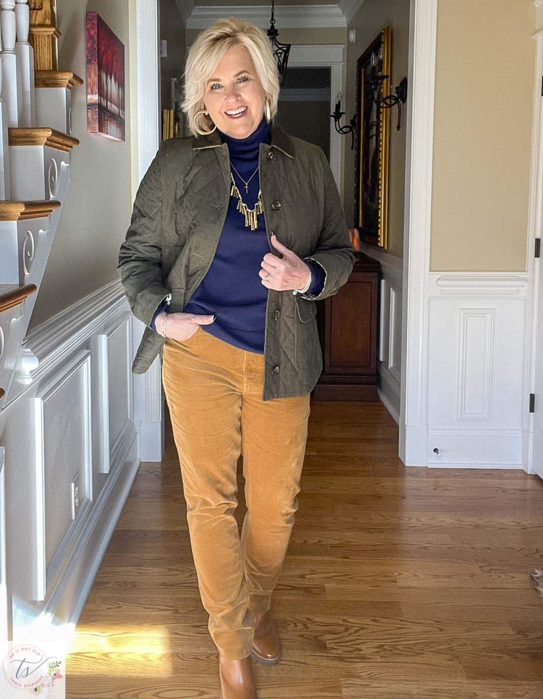 Over 40 Fashion Blogger, Tania Stephens is wearing a navy turtleneck, a green jacket, and caramel corduroy pants from Talbots