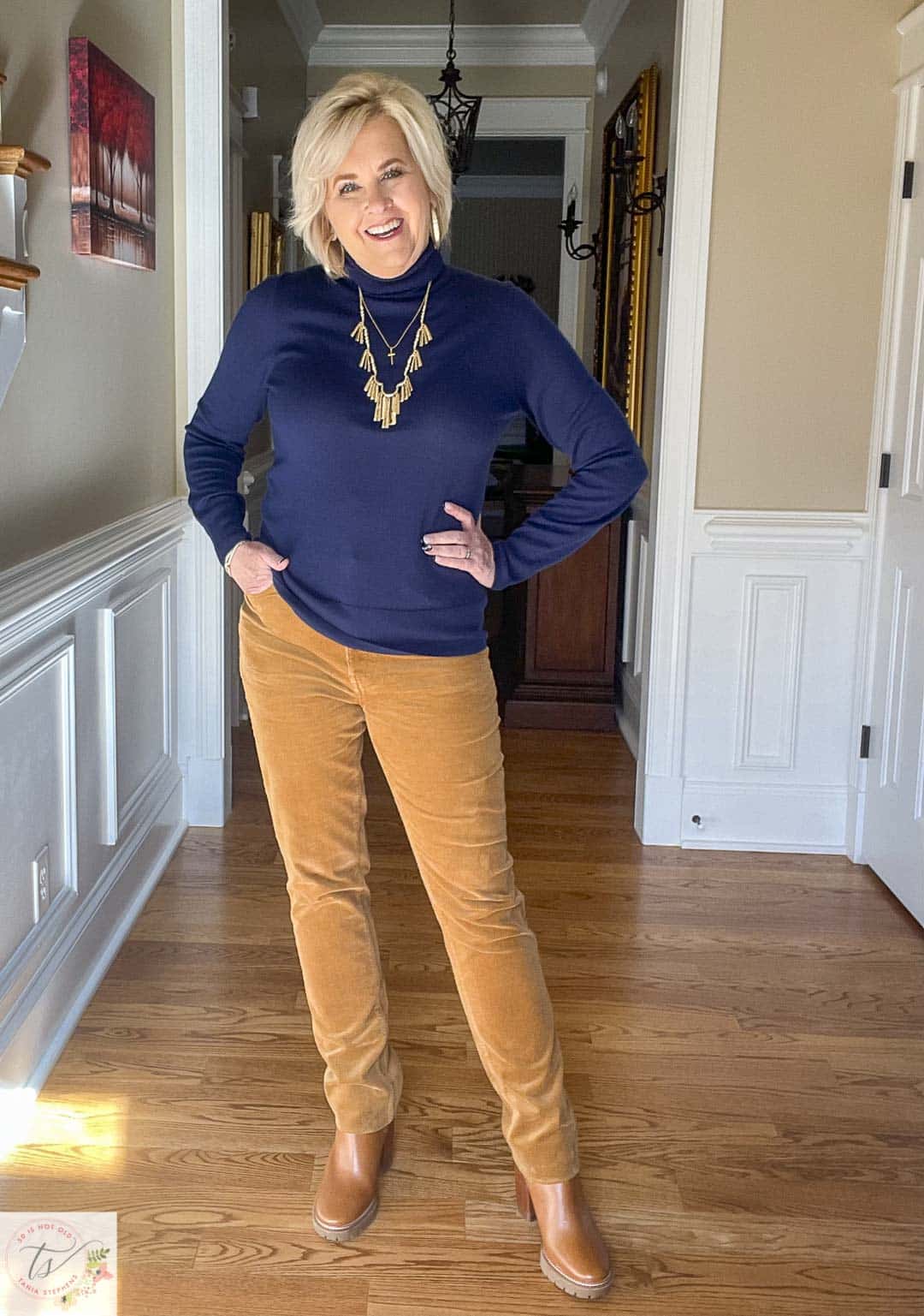 Over 40 Fashion Blogger, Tania Stephens is wearing a navy turtleneck with caramel corduroy pants from Talbots and gold jewelry from Kendra Scott