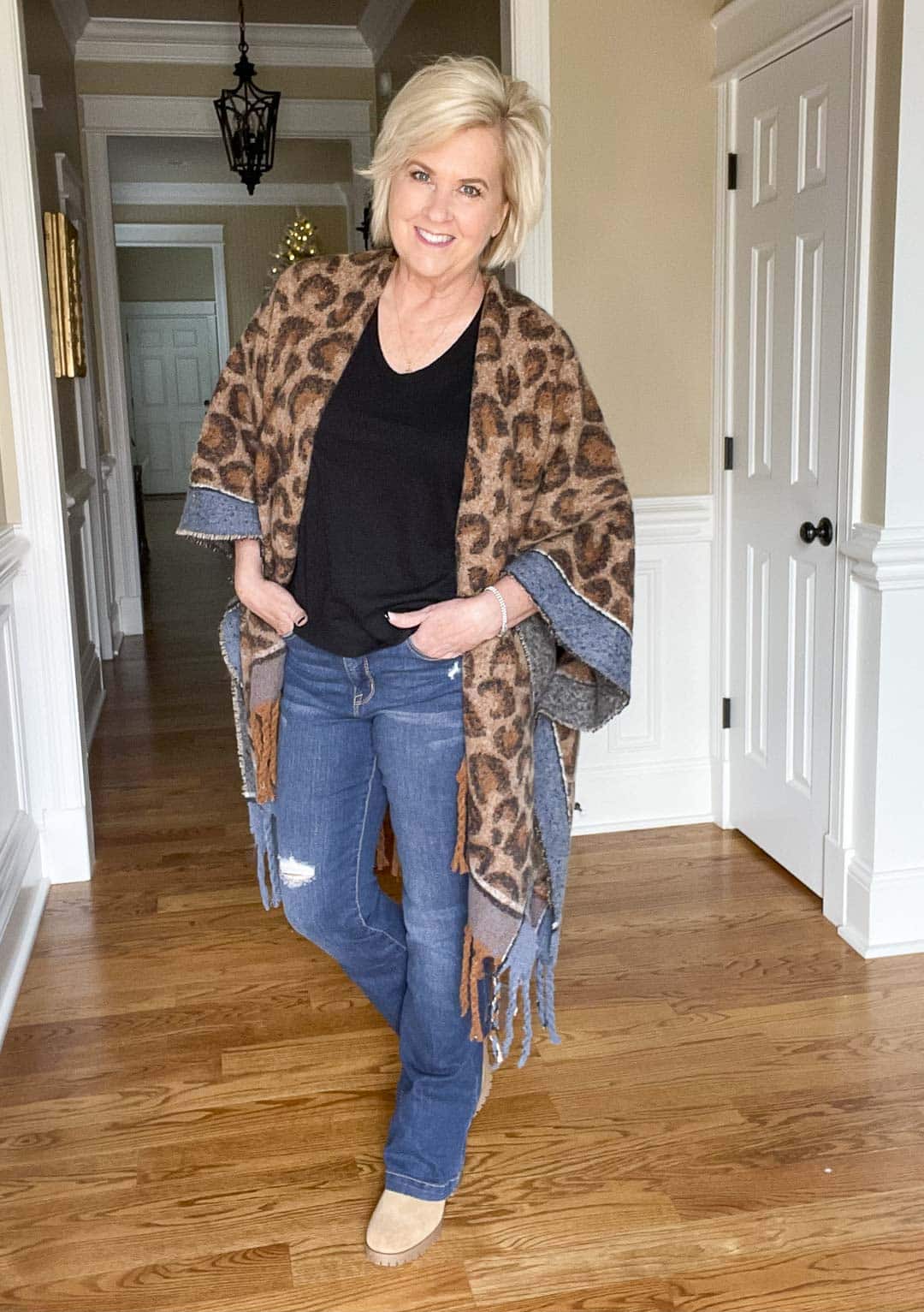 Over 40 Fashion Blogger, Tania Stephens is wearing a leopard print blanket wrap, distressed jeans, and a black t-shirt