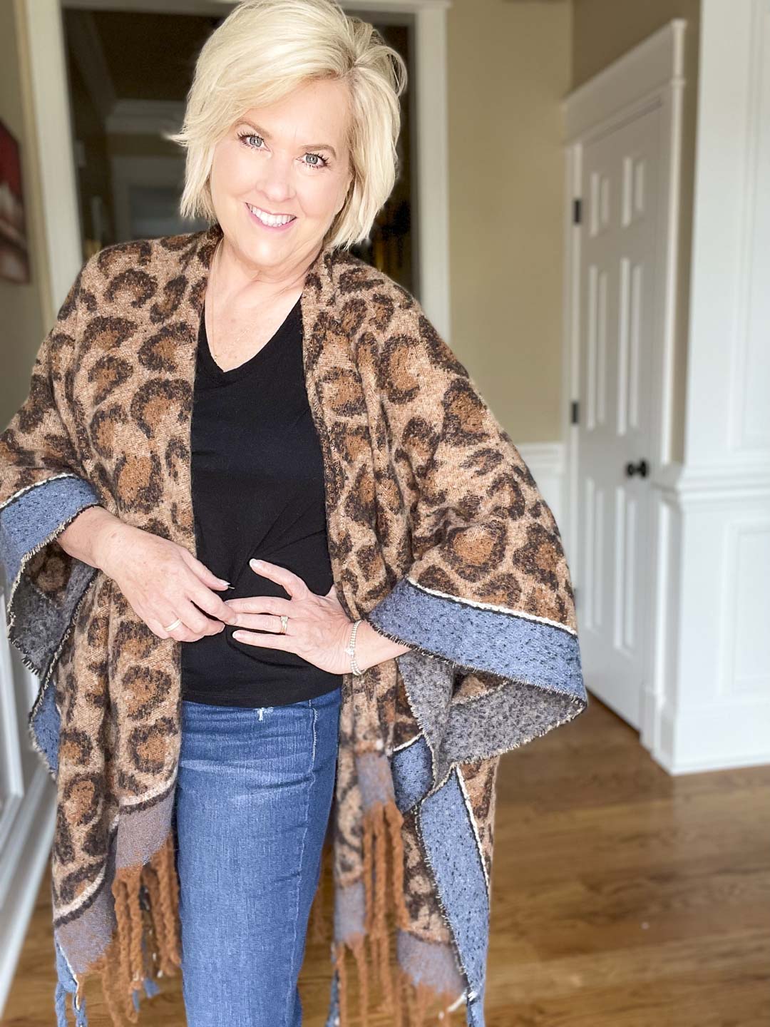 Over 40 Fashion Blogger, Tania Stephens is wearing a leopard print blanket wrap and a black v-neck t-shirt
