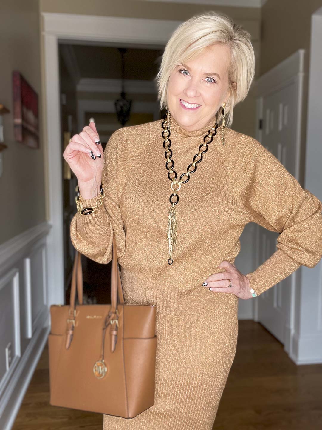 Over 40 Fashion Blogger, Tania Stephens is wearing a gold metallic sweater and black and gold jewelry