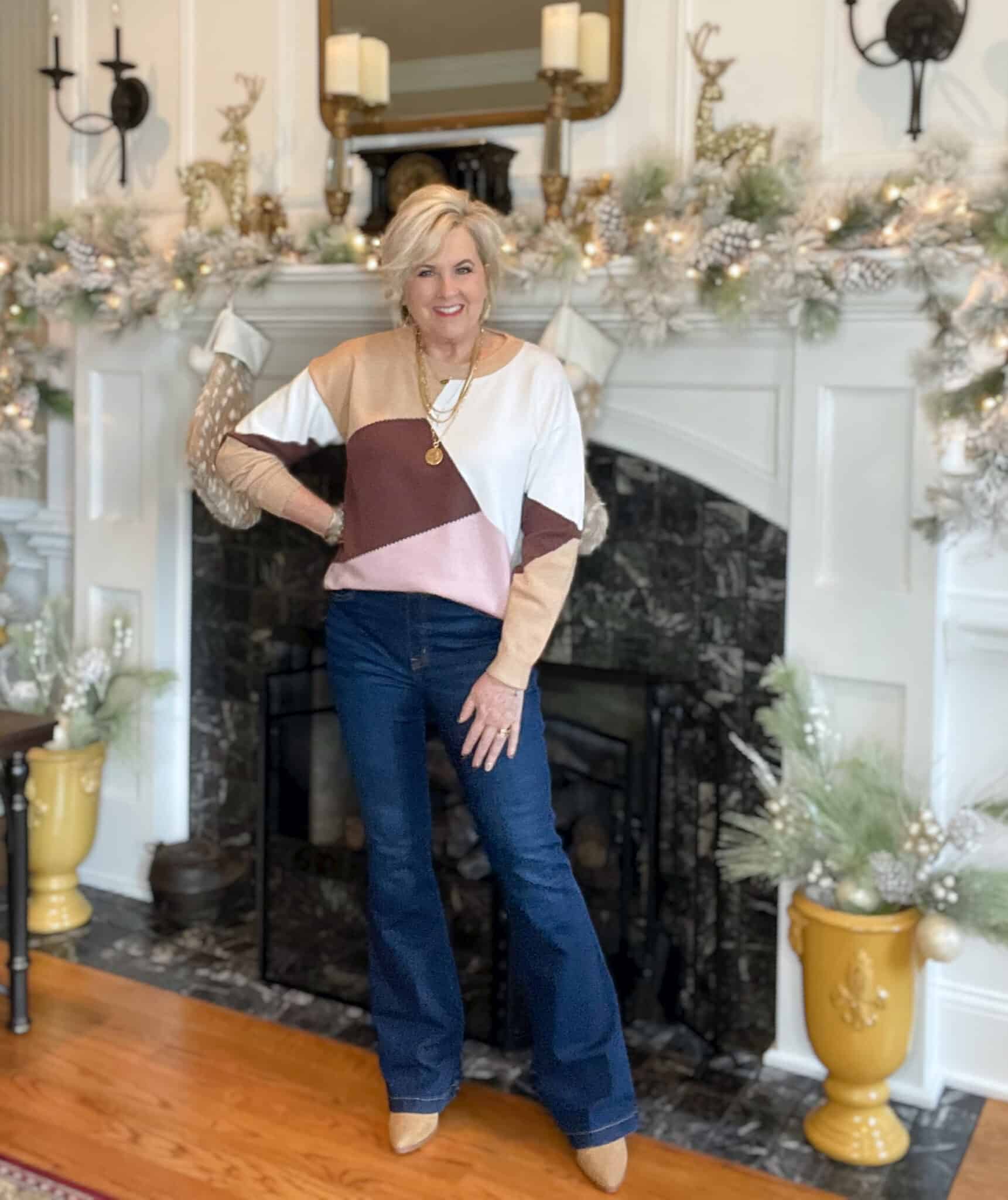 Over 40 Fashion Blogger, Tania Stephens is wearing a colorblock sweater with Spanx Flare jeans