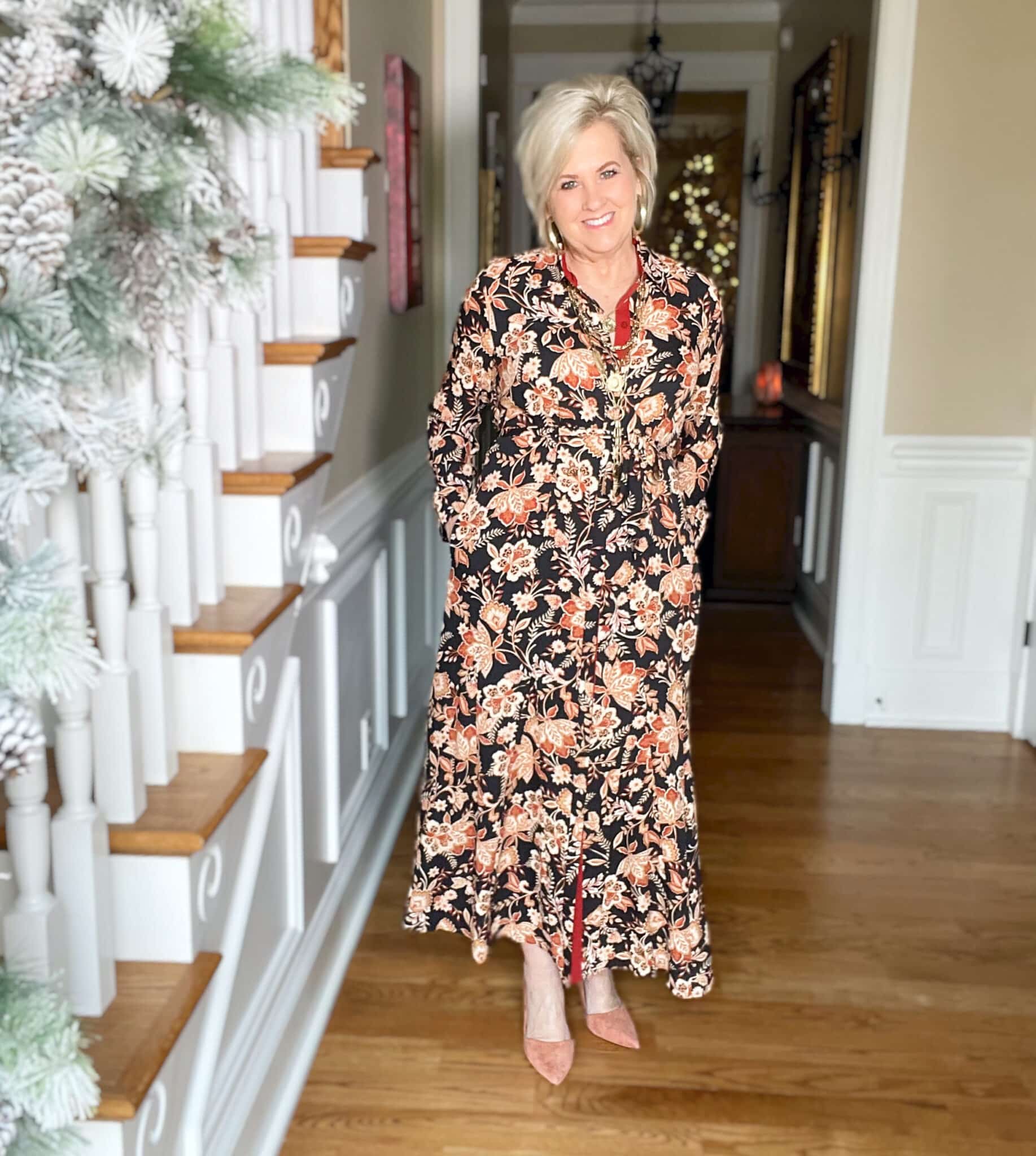 Over 40 Fashion Blogger, Tania Stephens is wearing a floral midi dress, gold jewelry, and clay heels