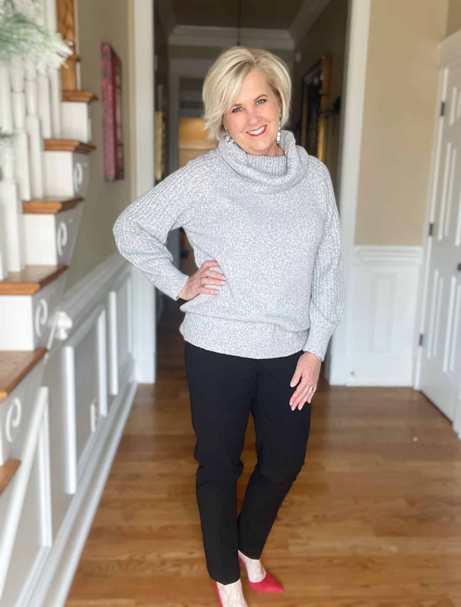 Over 40 Fashion Blogger, Tania Stephens is wearing a gray cowl neck sweater with black ankle pants for New Year's Eve