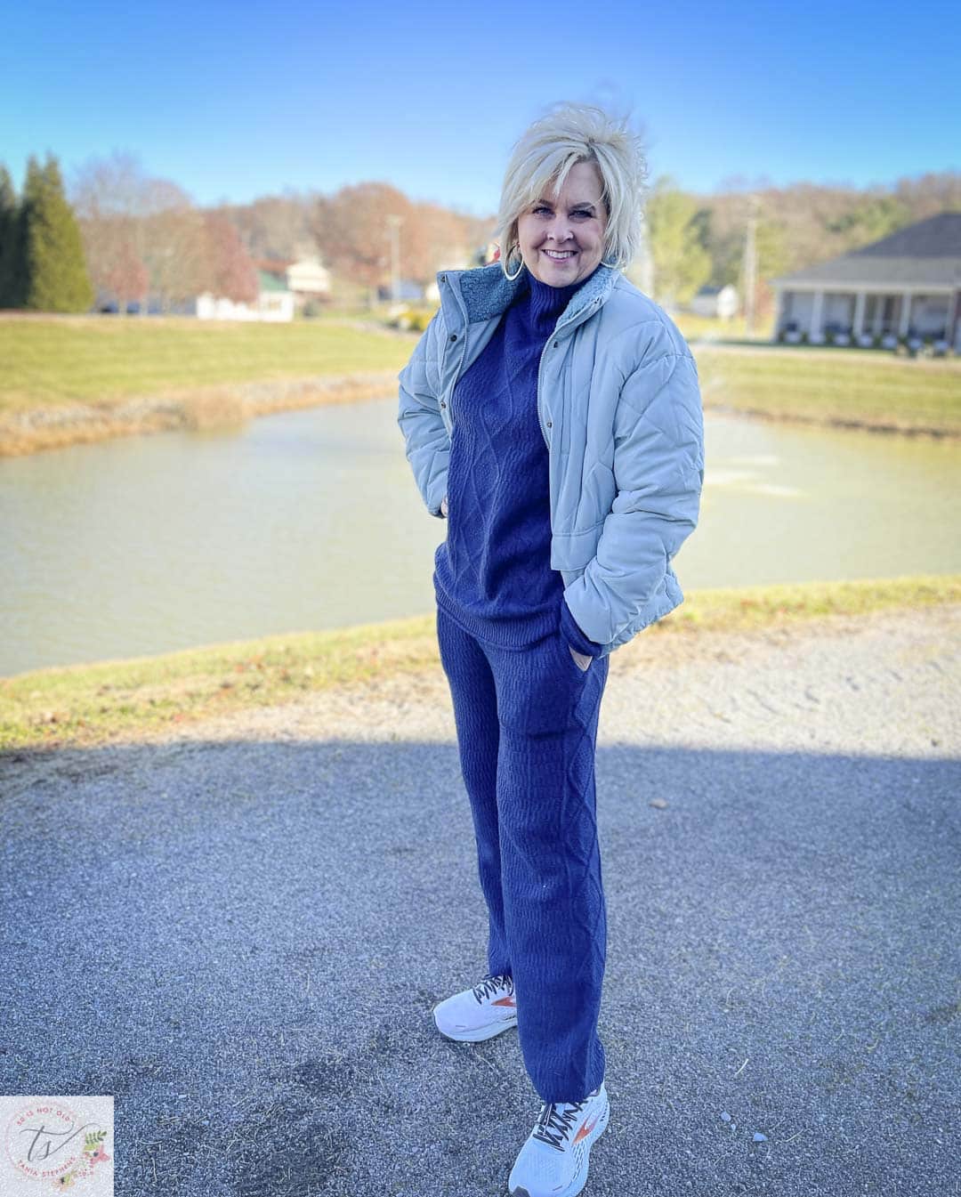 Over 40 Fashion Blogger, Tania Stephens is wearing a navy mockneck knit sweater set and an aqua puffer jacket with sneakers