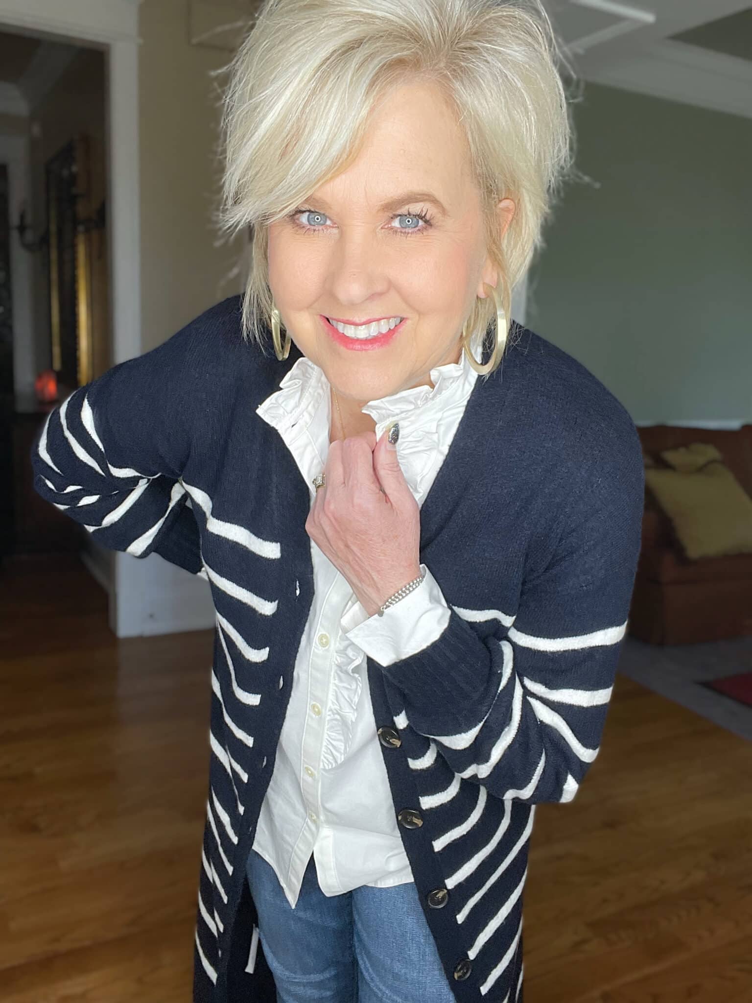 Over 40 Fashion Blogger, Tania Stephens is wearing a long navy and white cardigan with a white button up shirt and gold earrings