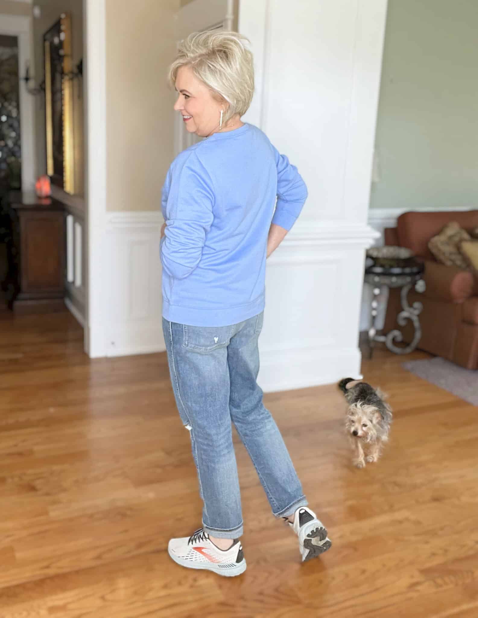 Over 40 Fashion Blogger, Tania Stephens is cozy in this blue Good Vibes sweatshirt and distressed jeans