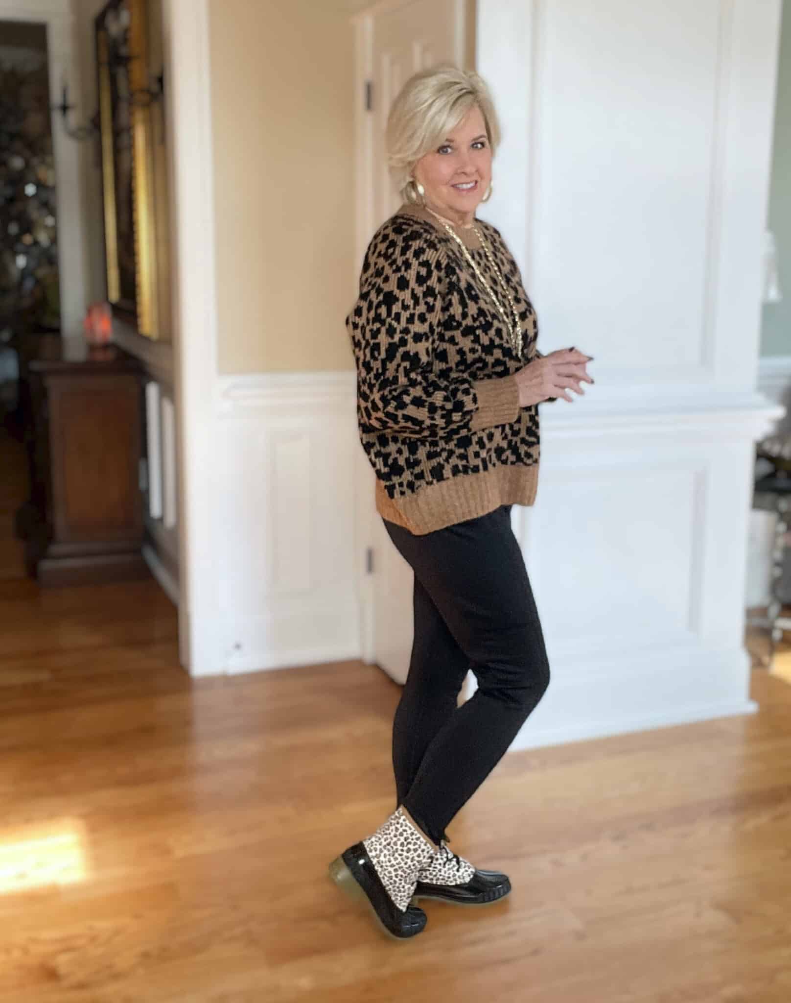 Over 40 Fashion Blogger, Tania Stephens is styling a leopard print sweater, black leggings and leopard print duck boots