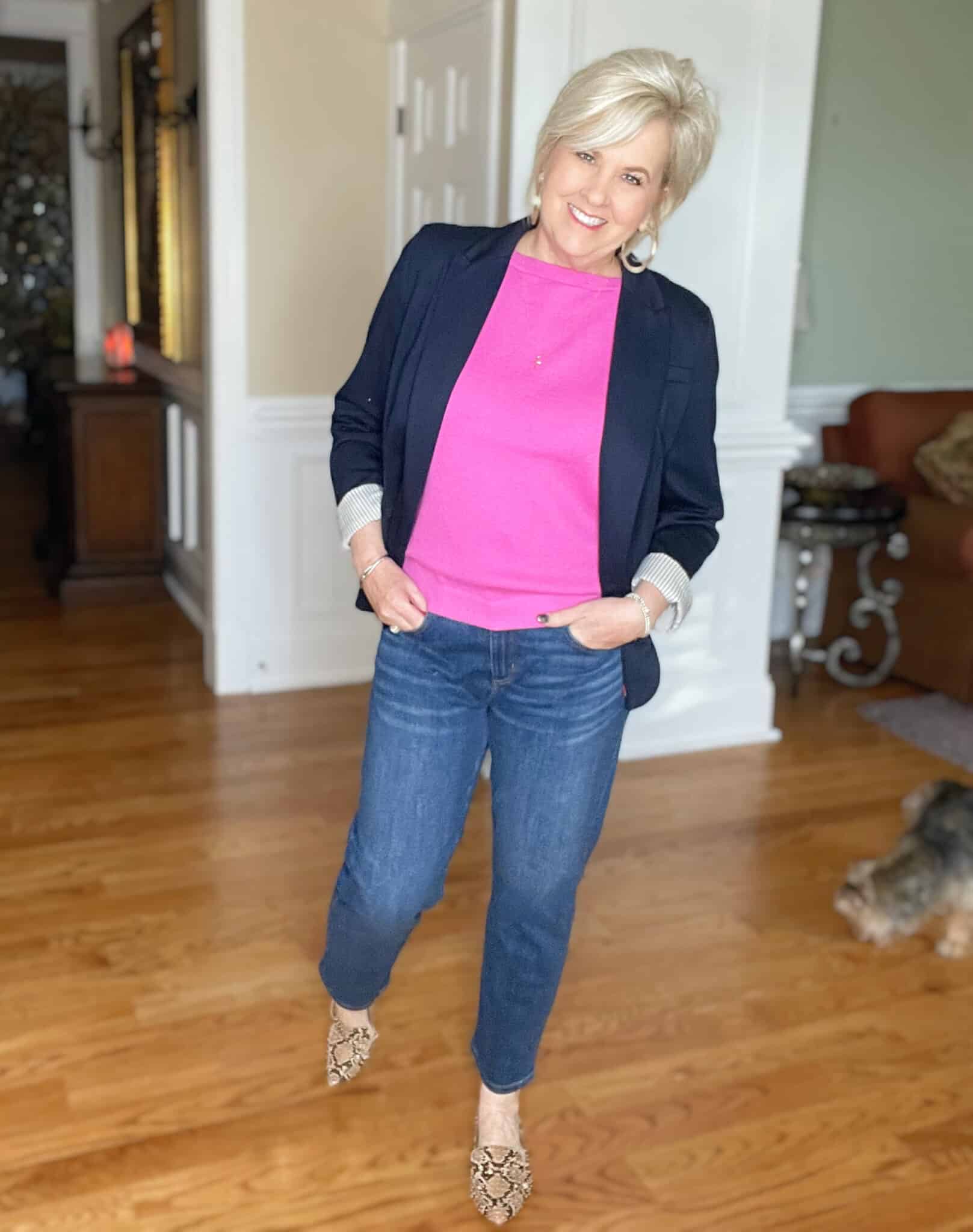 Over 40 Fashion Blogger, Tania Stephens is wearing a pink boatneck sweater, straight leg jeans, a navy blazer, and snakeskin print flats