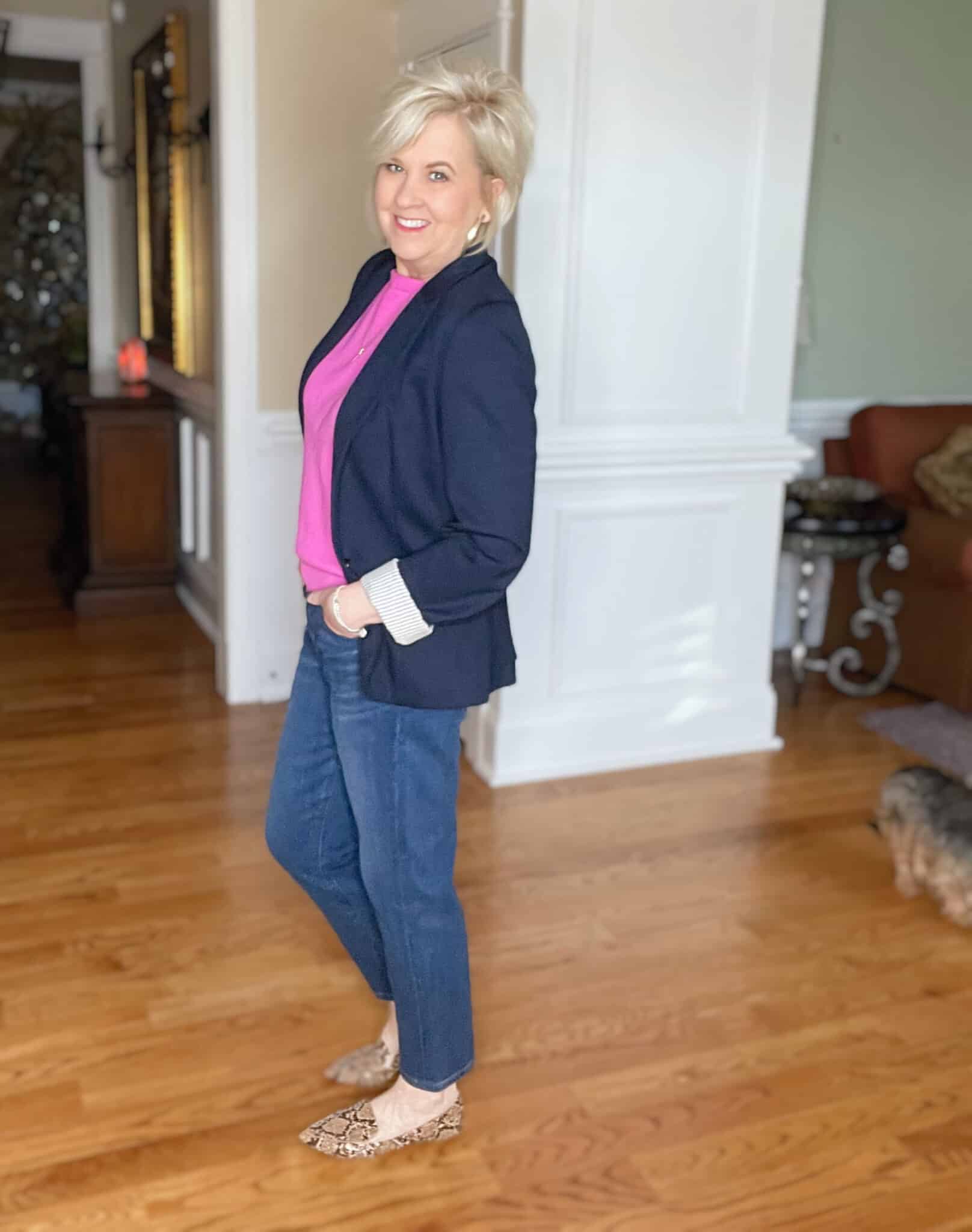 Over 40 Fashion Blogger, Tania Stephens is wearing a pink boatneck sweater, straight leg jeans, a navy blazer, and animal print flats